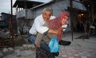 ENGELLİ EŞİNİ SIRTINDA TAŞIYOR VE ÇOCUK GİBİ BAKIYOR